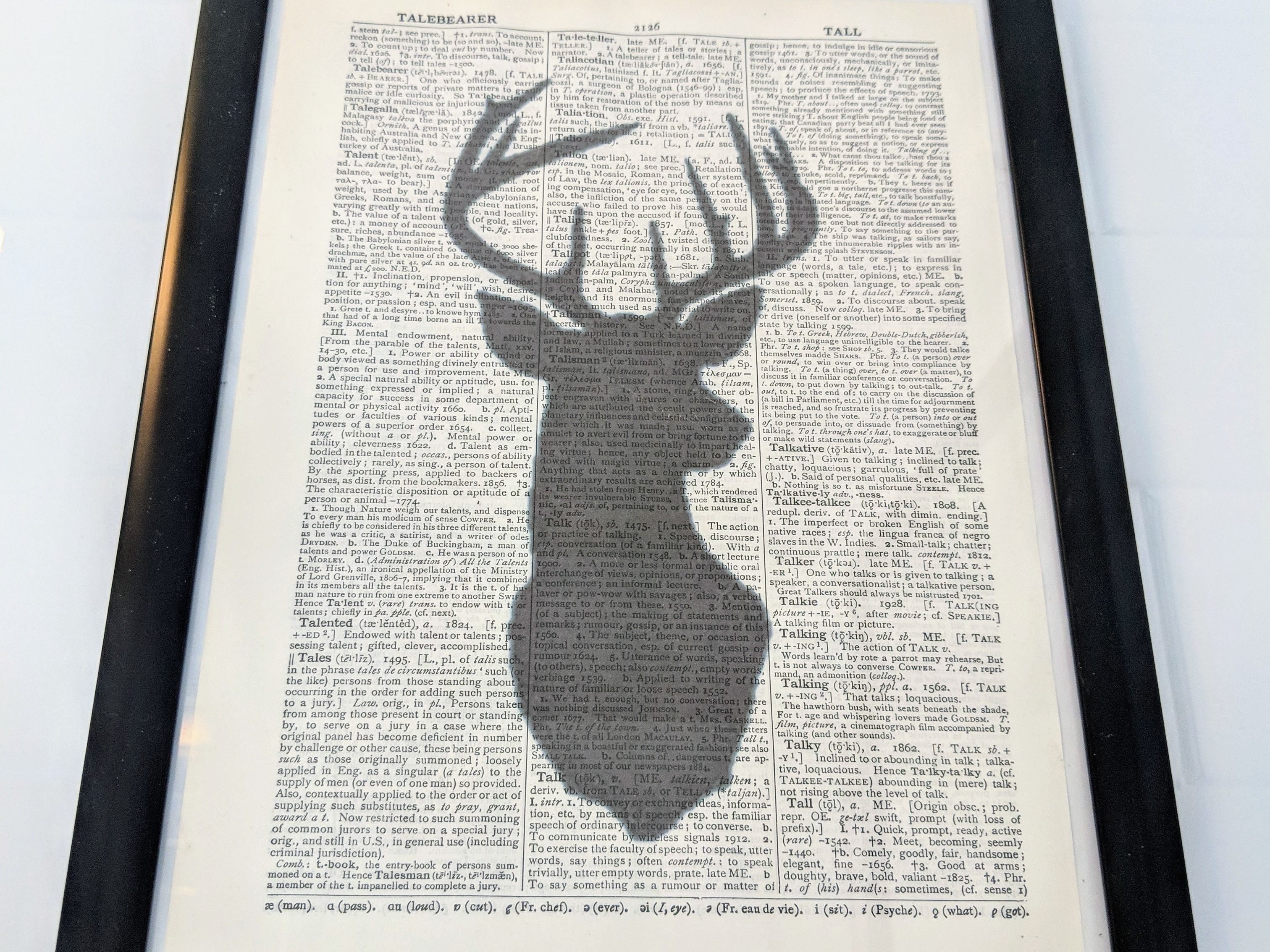 A page from a book with a large, dark silhouette of a deer head in the center.