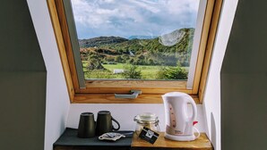 Ventana con tragaluz y vistas a un paisaje verde y colinas.