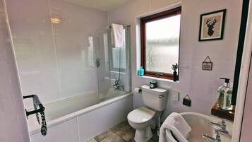 Une salle de bain avec une baignoire, des toilettes et un lavabo.