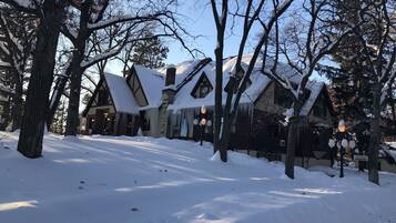Una cabaña cubierta de nieve con chimenea, estalactitas y un letrero que dice 'OFFICE'.