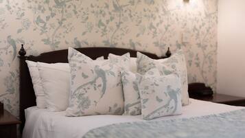 Ein Bett mit blumigem Kissenmuster und passendem Kopfteil.