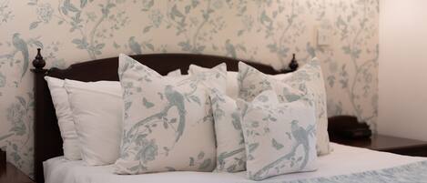 A bed with floral-patterned pillows and a matching headboard.