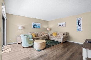 A living room with two sofas, a round coffee table, and a lamp.