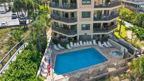 Un hôtel à plusieurs étages doté d’une piscine sur le toit, d’un espace extérieur aménagé et offrant une vue sur les environs.