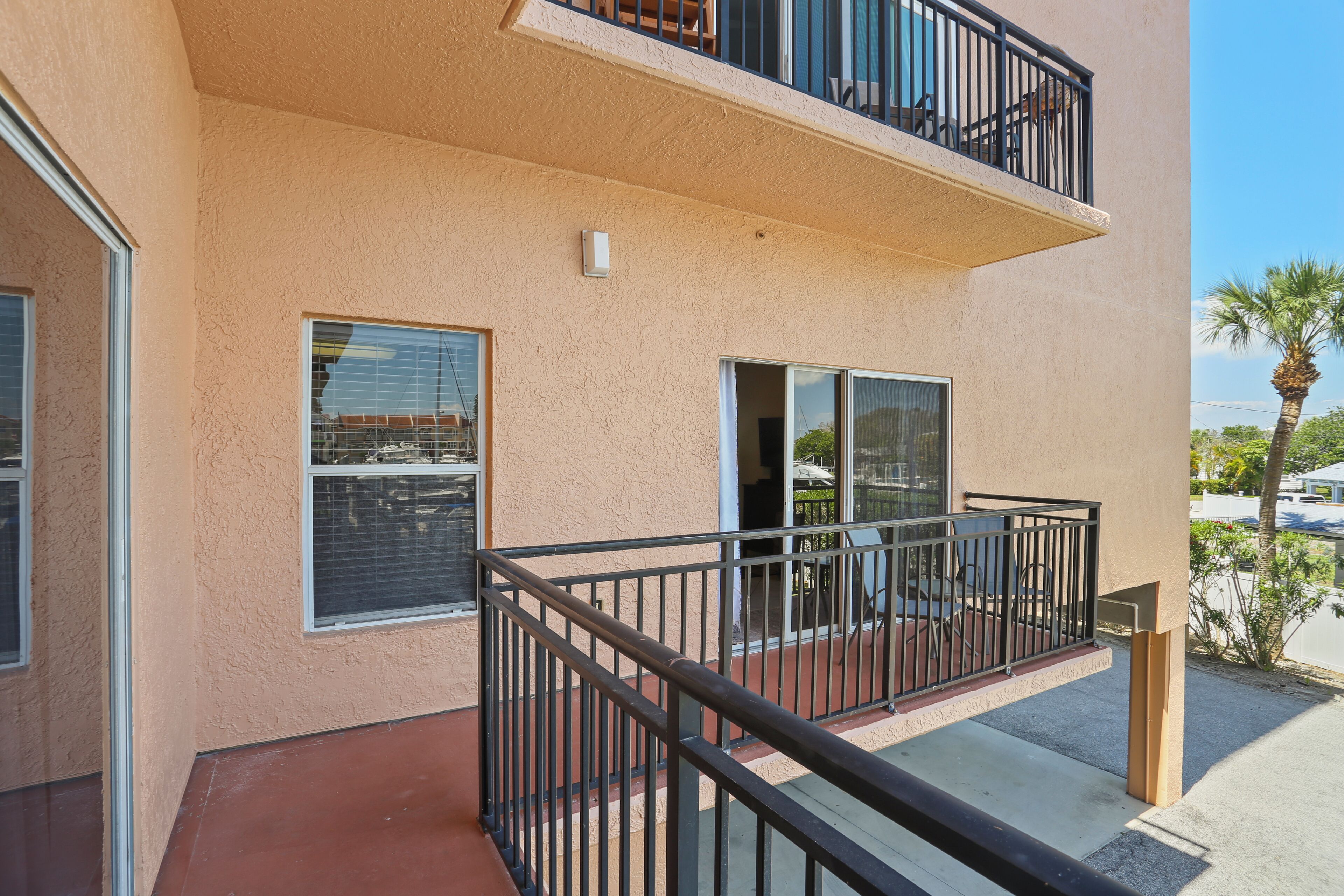 A two-story building with balconies, large windows, and a clear view of the surrounding area.