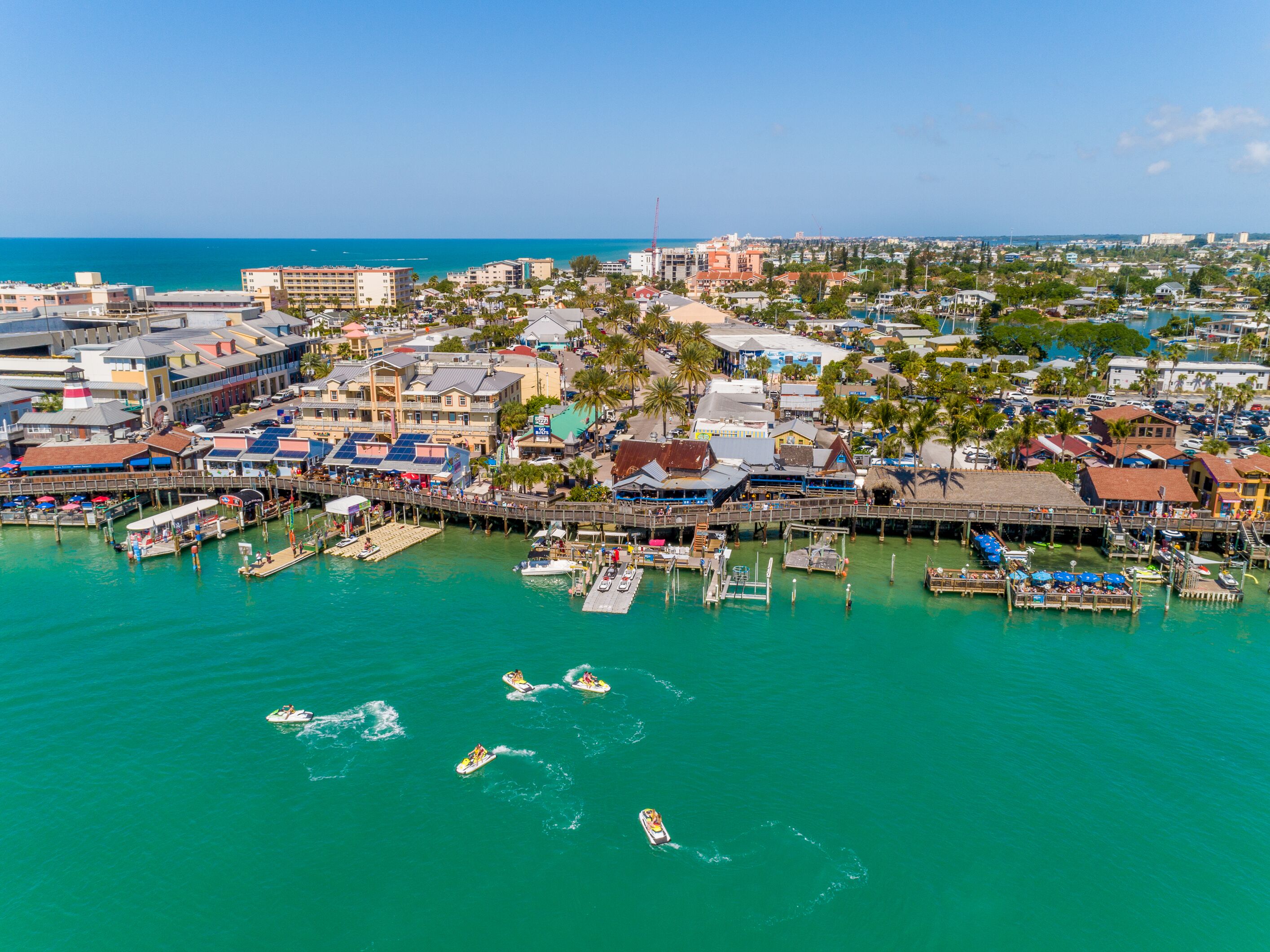 A coastal town with a marina, boats, and buildings.