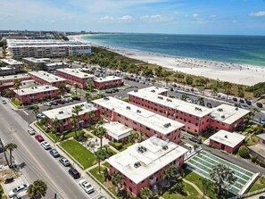 Une zone résidentielle côtière avec des immeubles d’appartements, une plage et un ciel dégagé.