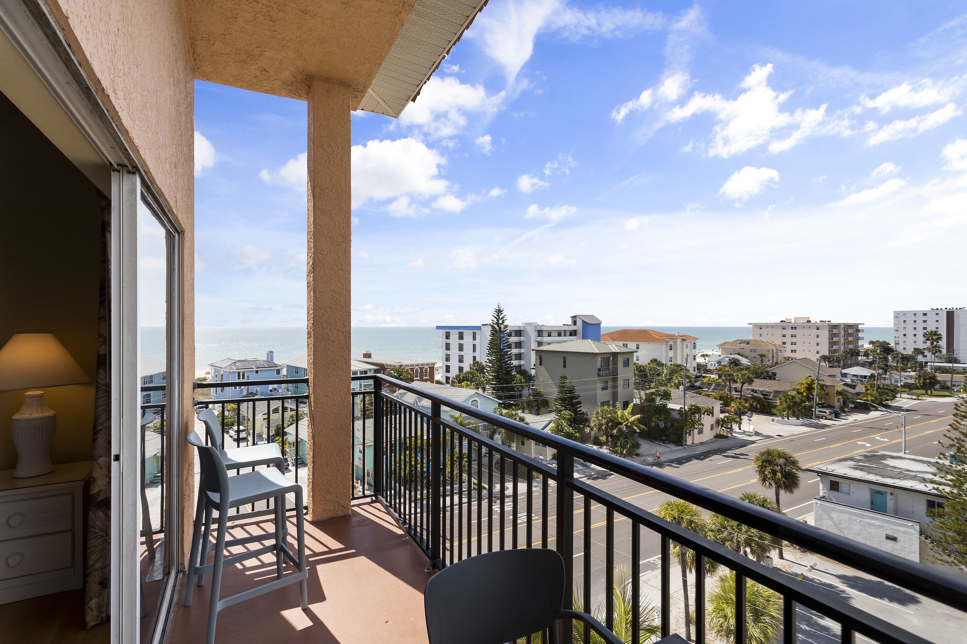 A balcony with a view of the sea and buildings.