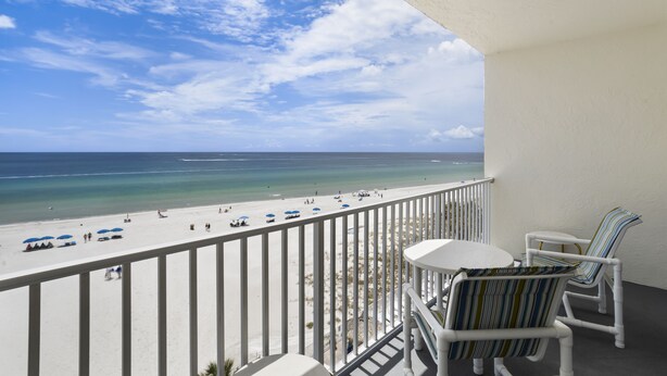 Un balcon avec vue sur une plage et l’océan.