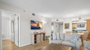Una sala de estar moderna con un sofá, una mesa de centro y un cuadro de un atardecer.
