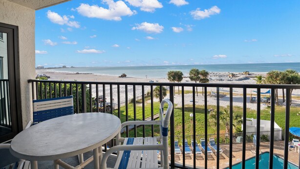 Ein Balkon mit Blick auf den Strand, einen Pool und Sitzgelegenheiten im Freien.