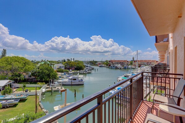 A balcony with a view of a marina, boats, and buildings.