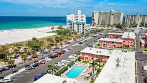 Ein Strandhotel mit Pool, Parkplatz und Meerblick.