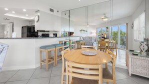 Eine moderne Küche mit Essbereich, großen Fenstern und einem Balkon.