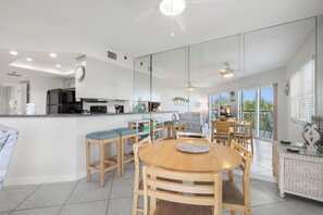Une cuisine moderne avec un coin repas, de grandes fenêtres et un balcon.