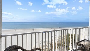 A balcony with a view of a beach and ocean.