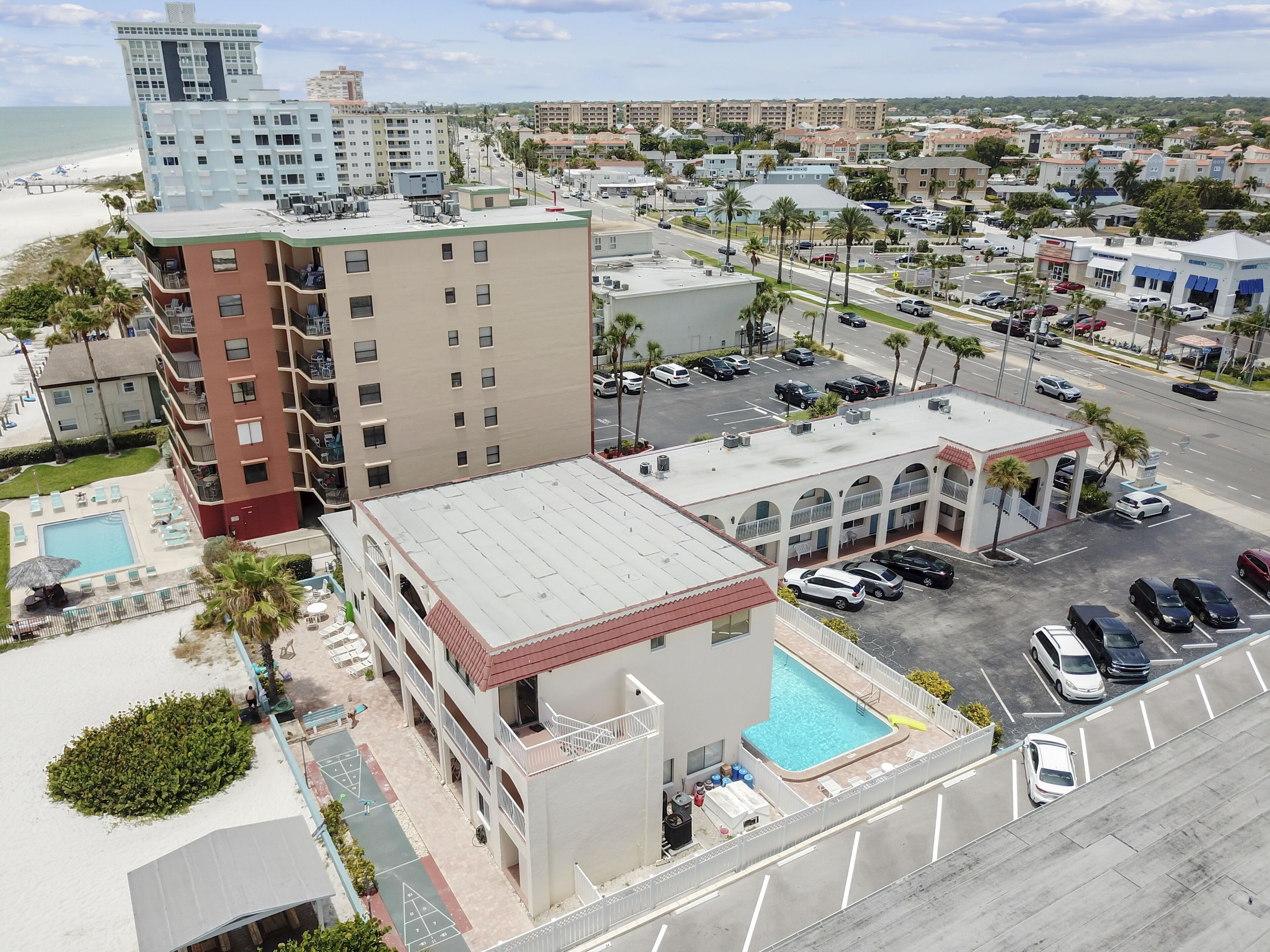 Un hôtel doté d’une piscine sur le toit, d’un parking et offrant une vue sur la plage et l’océan.