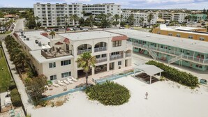 A hotel with multiple floors, outdoor seating, and a pool area.