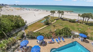 A resort with a pool area, beach access, and a view of the ocean.