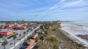 A coastal area with a beach, parking lots, and buildings.