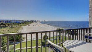 Uma varanda com vista para a praia e o oceano.