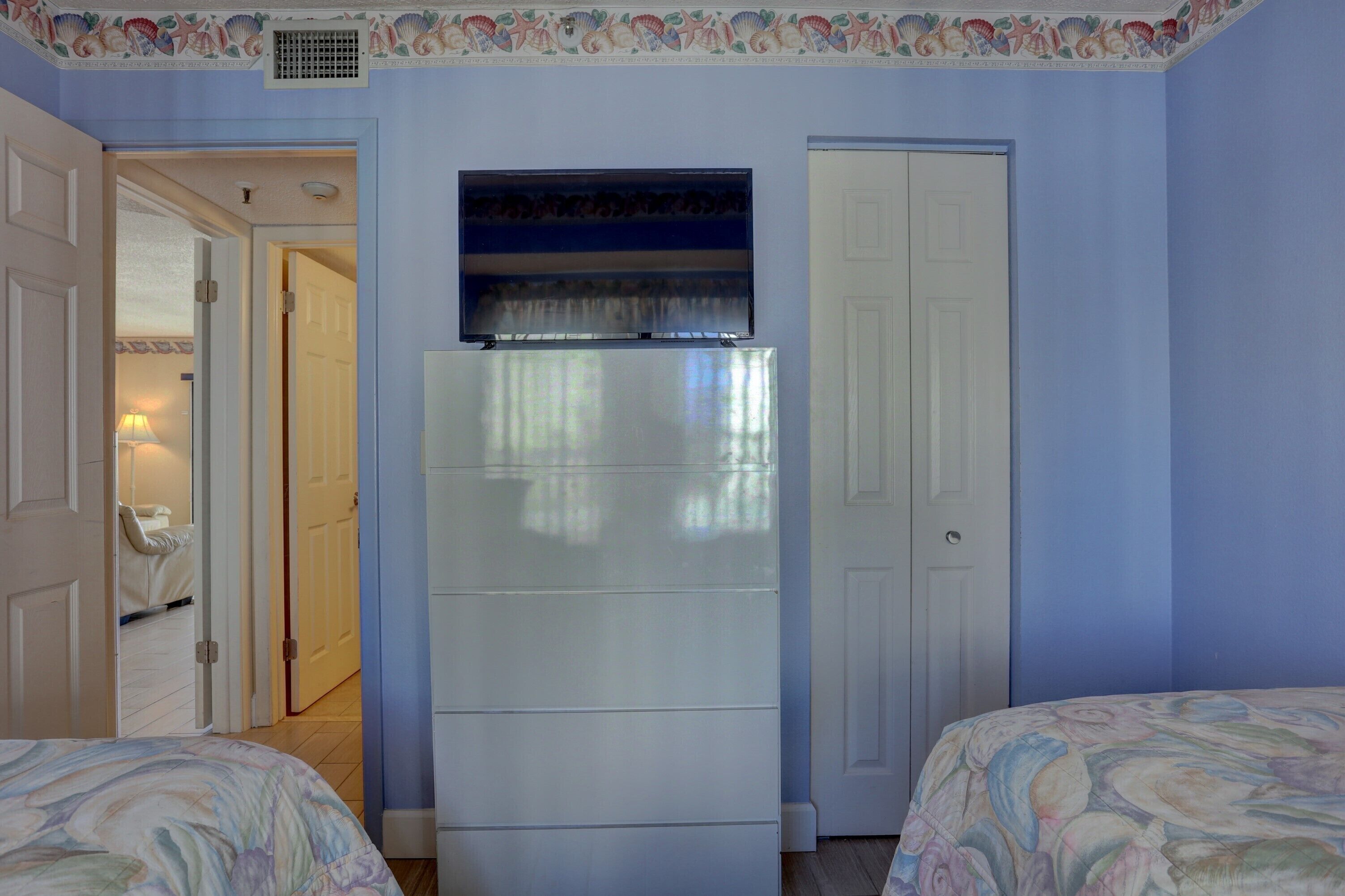 Una camera da letto con un letto, un armadio e una porta che dà su un'altra stanza.