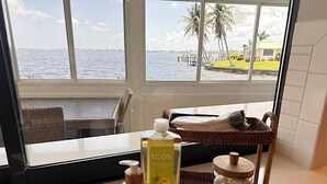 A bathroom with a view of the ocean, a wicker basket, and toiletries. - The River View 1008 - SE Cape Coral Riverfront Luxury Pool Home Pool Table and more (Cape Coral)