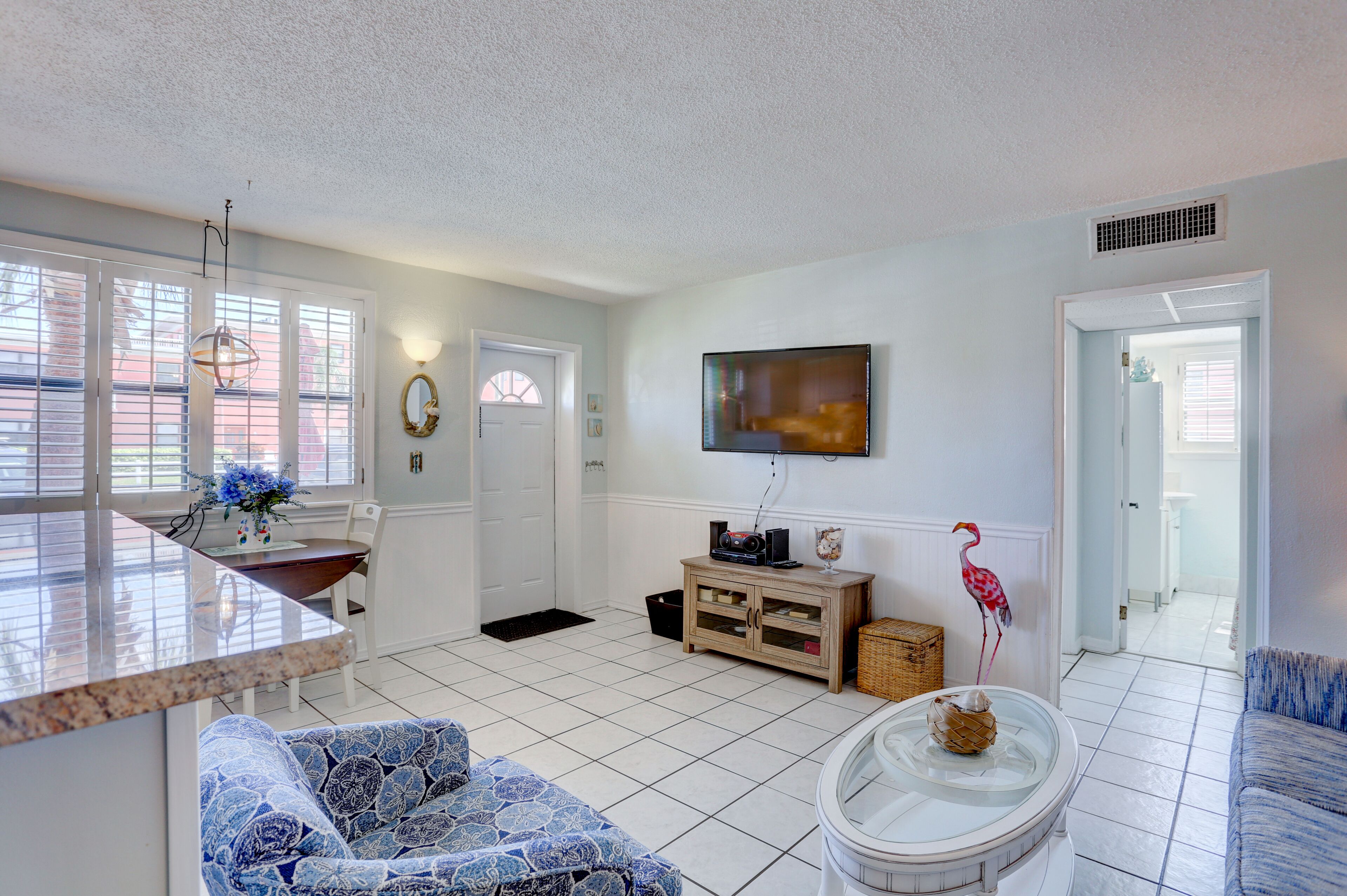 A spacious living area with a kitchen island, a dining table, and a seating area with patterned sofas.