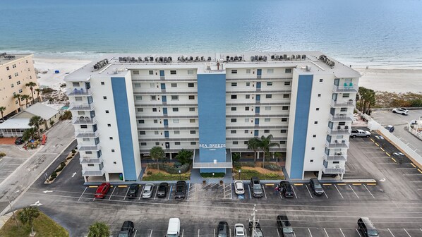 A multi-story hotel with a central atrium labeled "SEA BREEZE 13500" and a parking lot in front.