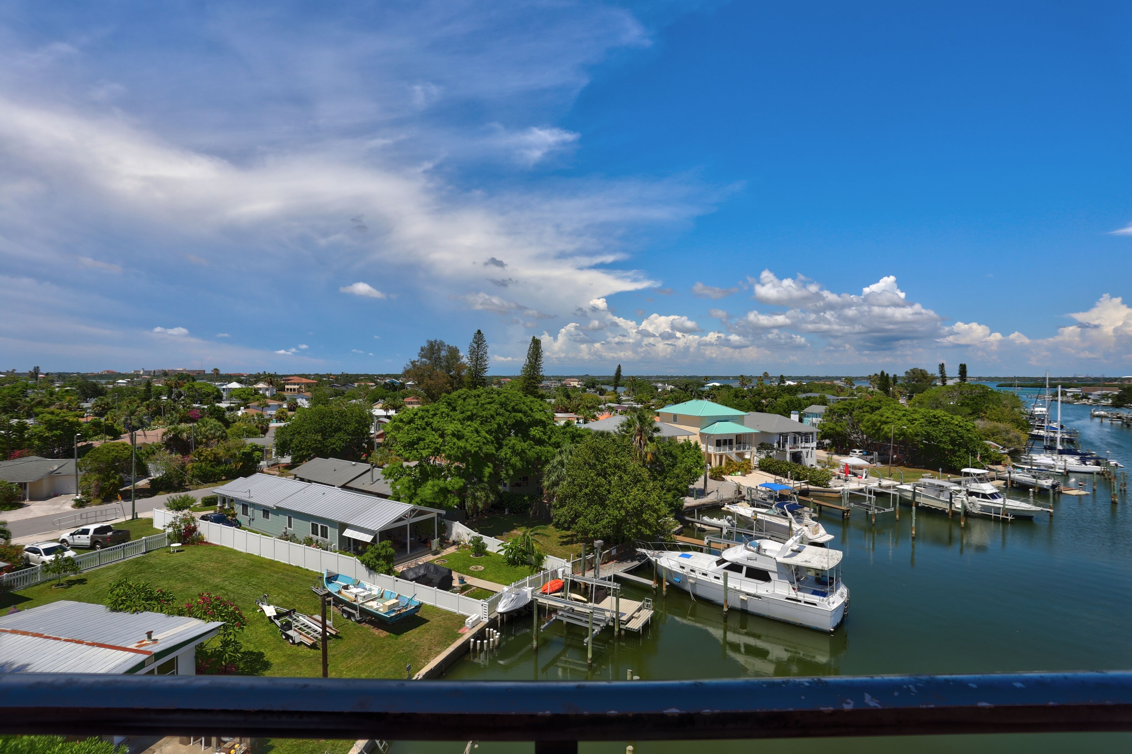 A marina with boats docked, surrounded by residential houses and greenery.