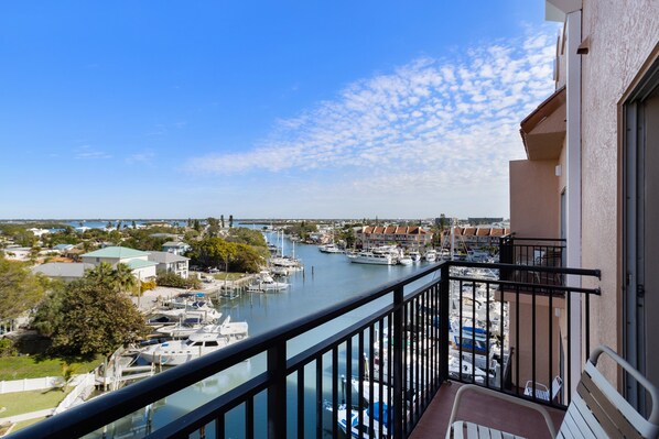 A balcony with a view of a marina and surrounding buildings.