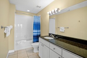 A bathroom with a bathtub, toilet, and sink.
