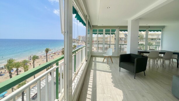 A balcony with a view of the beach and ocean.