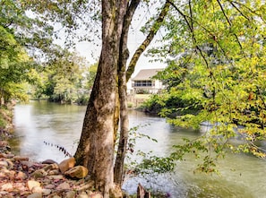 A river with a house in the background.
