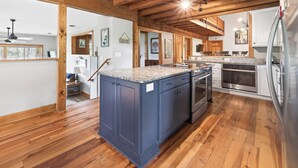 Una cocina con vigas de madera, encimeras de granito y electrodomésticos de acero inoxidable.