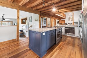A kitchen with wooden beams, granite countertops, and stainless steel appliances.