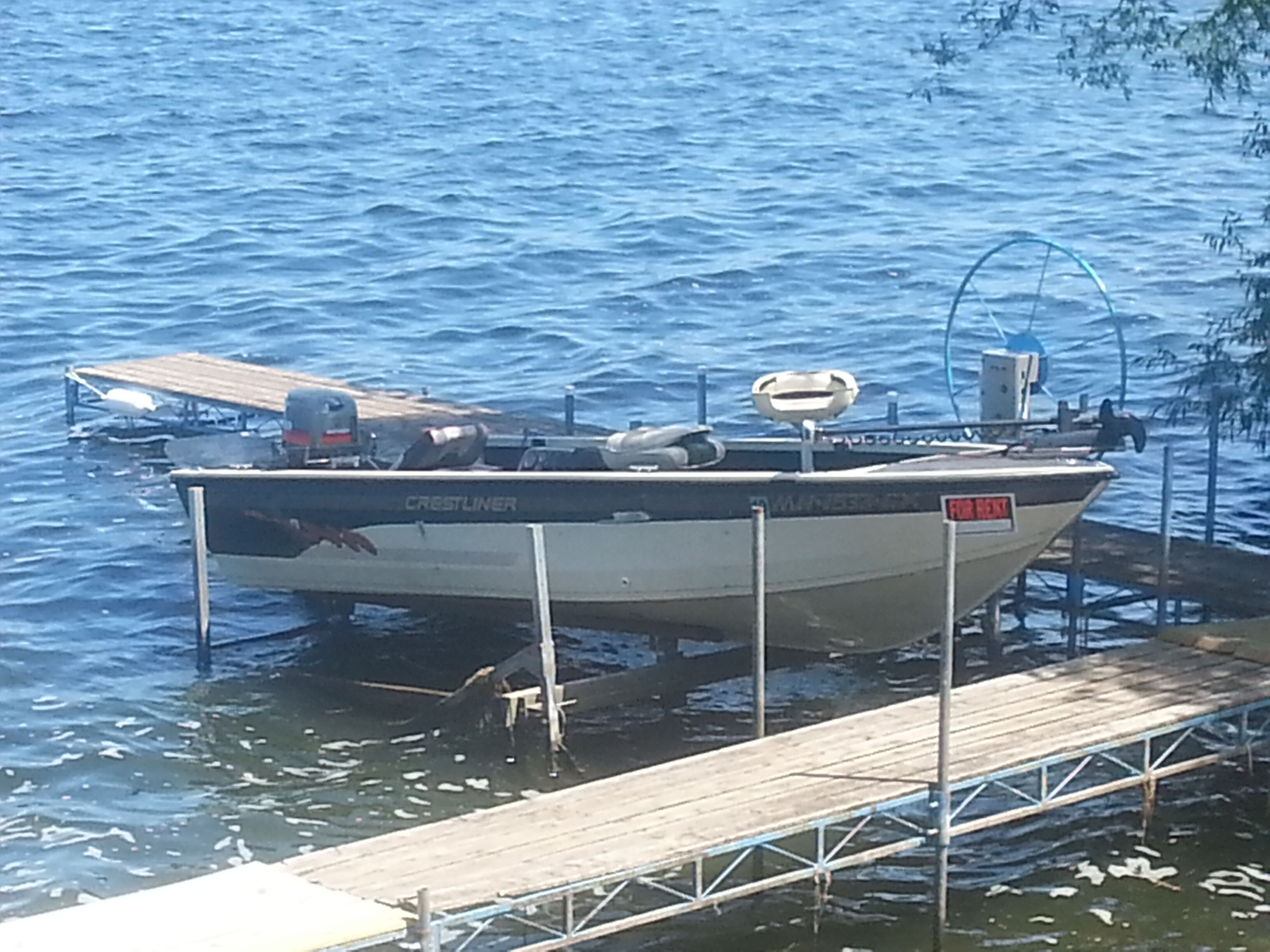 A boat named 'Crestliner' docked at a pier.