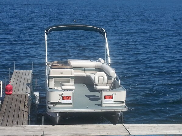A boat docked at a wooden pier with a 'FOR RENT' sign on the back. - Cottage 4 is great for family gatherings, & fishing on Lake Osakis! (Osakis)