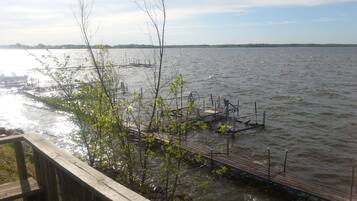 A wooden dock extending into a calm body of water with a distant shoreline.