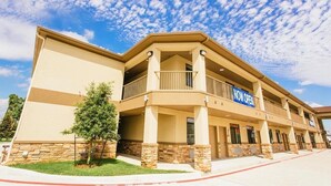 A hotel with a two-story structure, a balcony on the second floor, and a 'NOW OPEN' sign. - Palace Inn Conroe (Conroe)