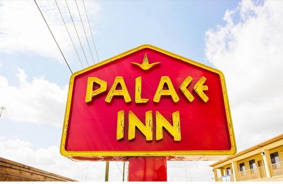 A red sign with yellow lettering that reads "PALACE INN".