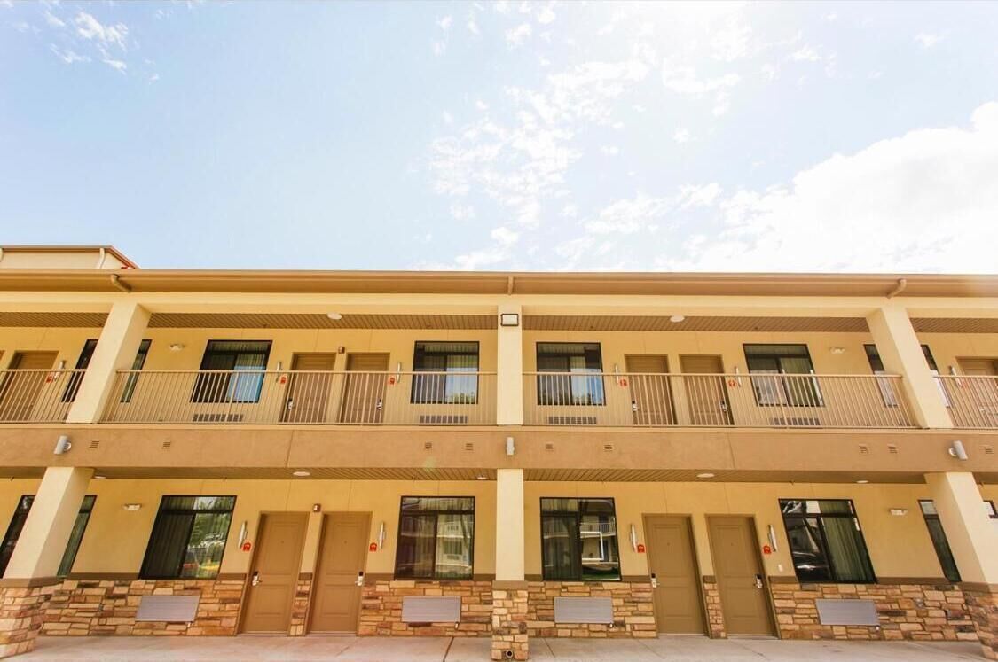 Un hotel de varios pisos con balcones, techo plano y fachada de ladrillo.