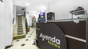 A reception area with a sign for 'Ayenda Rooms', a staircase, and a tiled floor. - Ayenda 1016 Bogotá Chapinero (Bogotá)