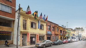 A row of colorful buildings with flags, including a hotel with a sign that reads "HOTEL". - Ayenda 1016 Bogotá Chapinero (Bogotá)