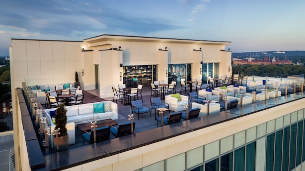 A rooftop bar with outdoor seating, a bar area, and a view of a cityscape. - Hyatt House Augusta Downtown (Augusta)