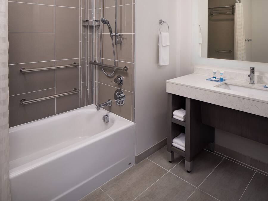 A modern bathroom with a bathtub, shower, and vanity.