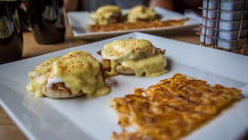 Een bord met eggs benedict en een stuk pizza.