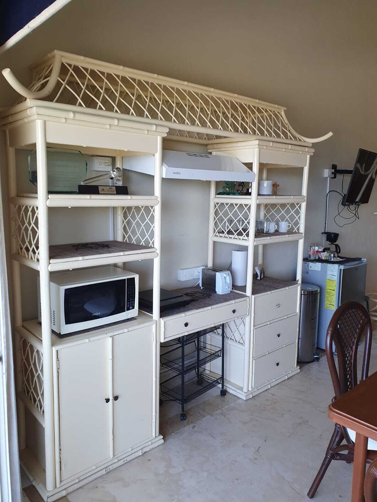 A compact kitchenette with a microwave, toaster, and small refrigerator.
