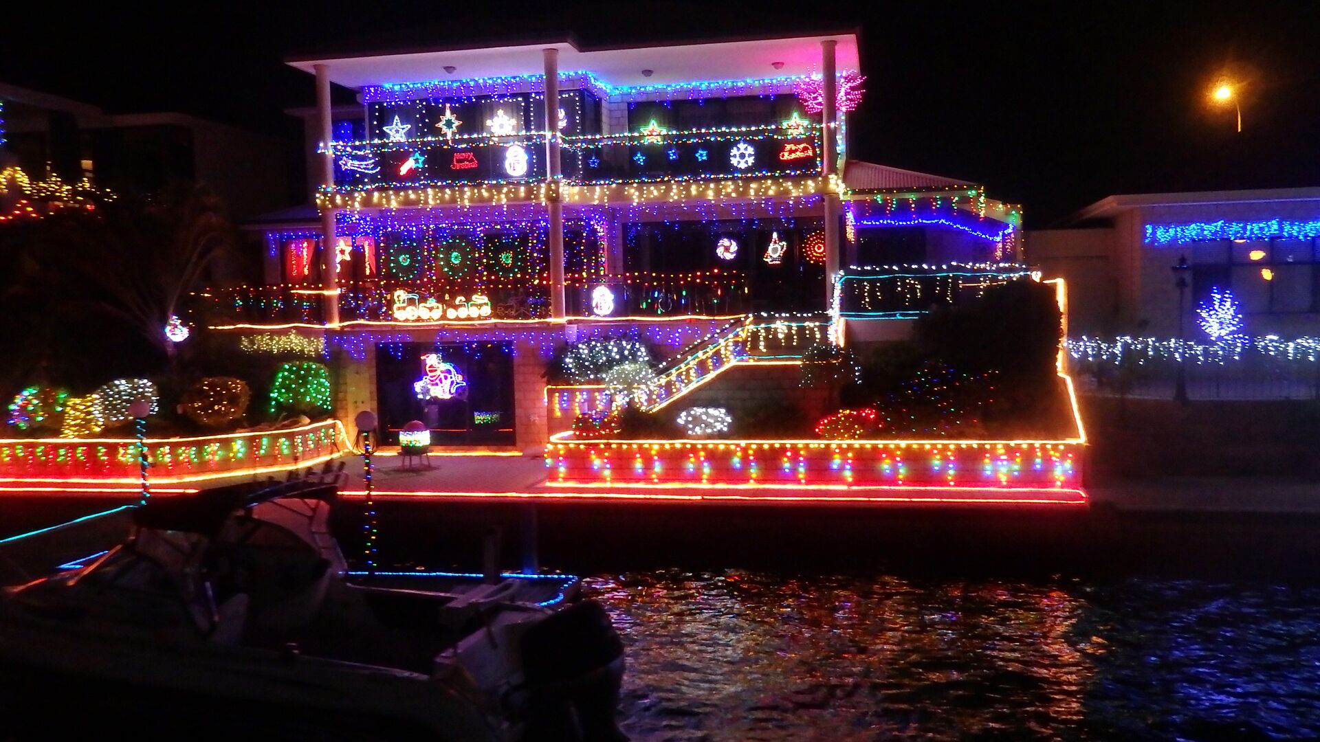 A multi-story building with a flat roof, adorned with colorful lights and decorations.