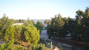 A residential area with a clear view of a street, trees, and houses. - Perkovic apartment Ana is just 50 m from the inviting beach in Kaštel Štafić (Kaštel Štafilić)